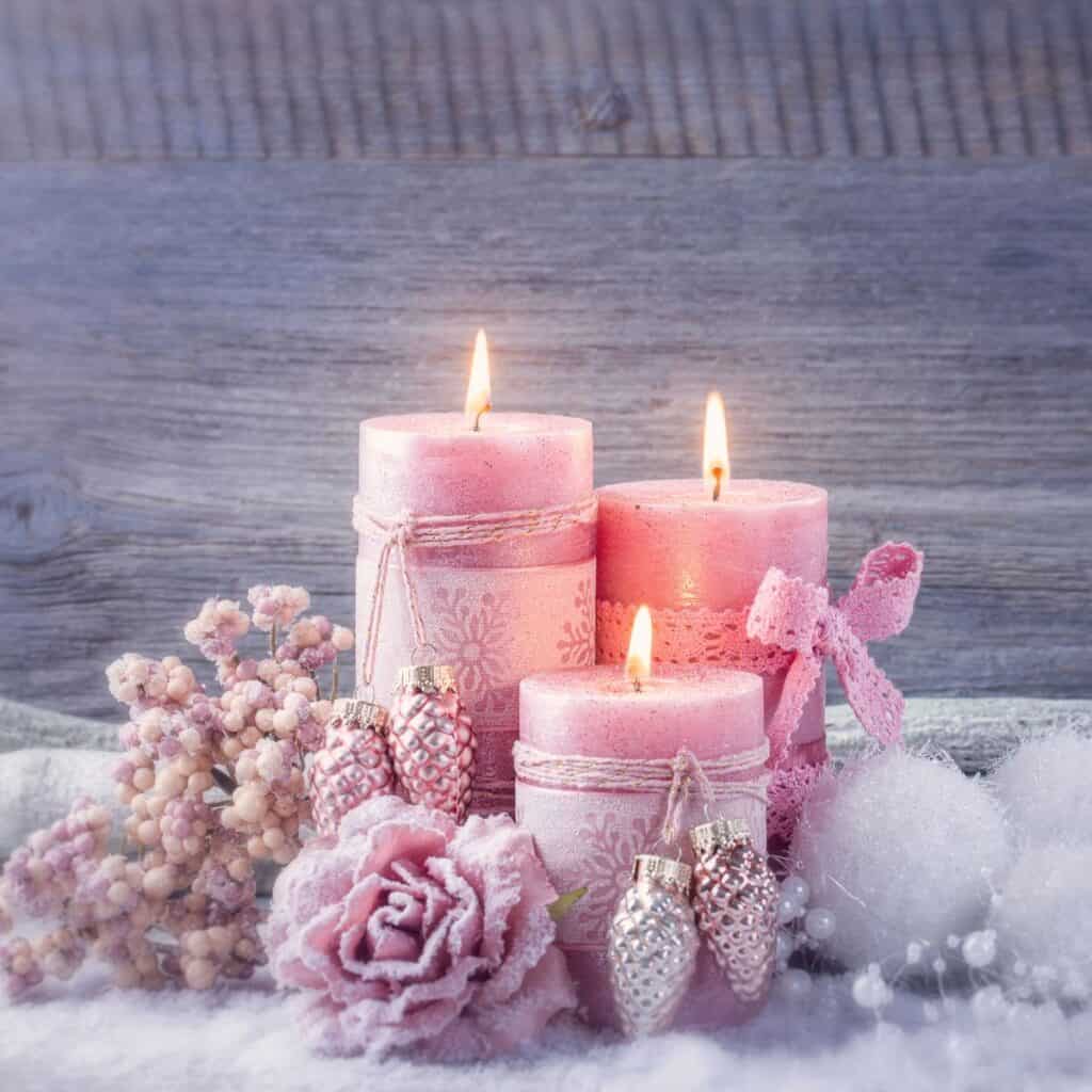 Pink winter themed candles on a wintery background