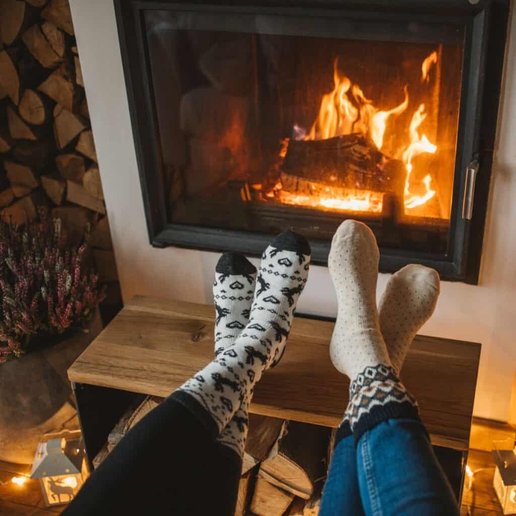 crossed feet in winter socks in front of a fireplace