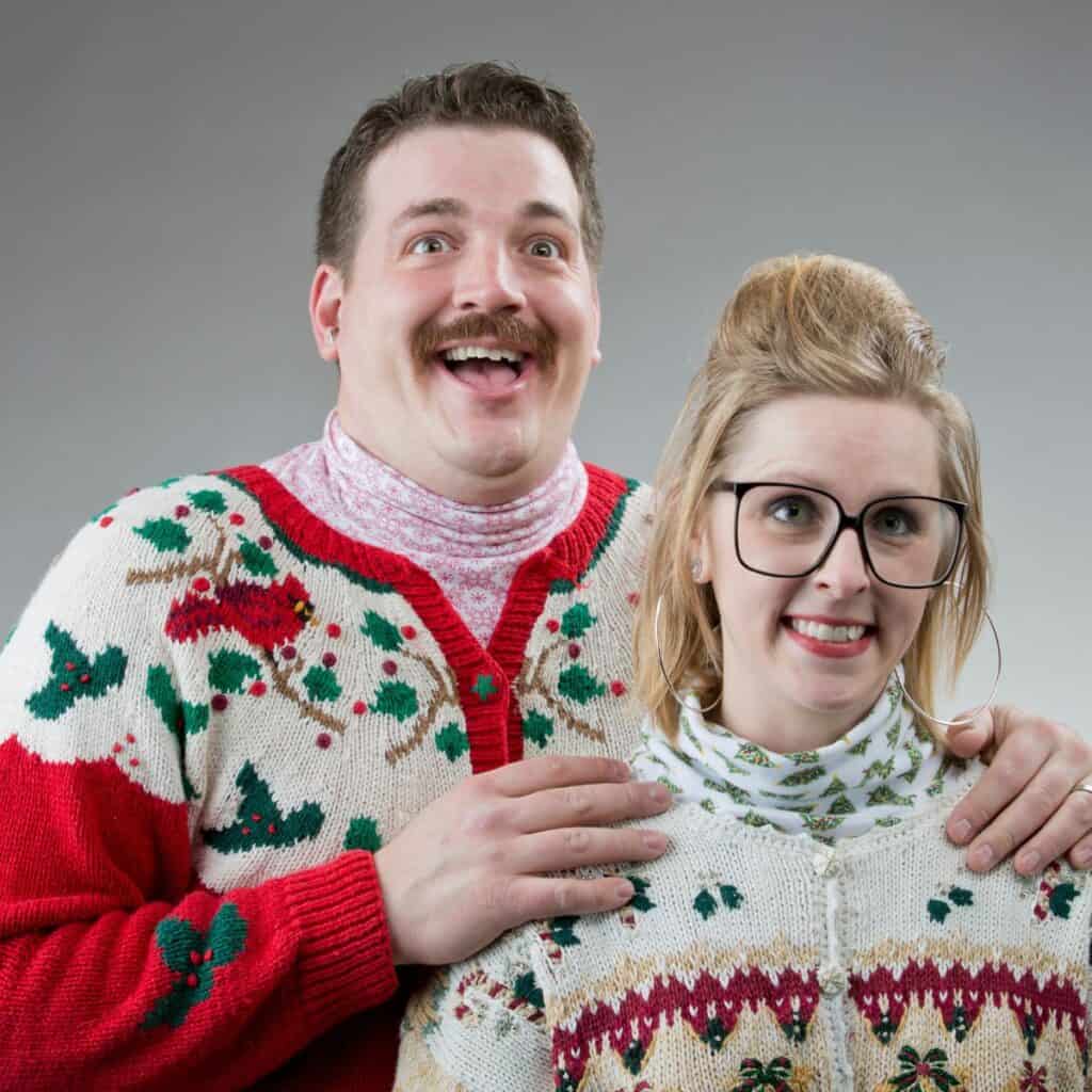 Smiling couple in ugly Christmas sweaters