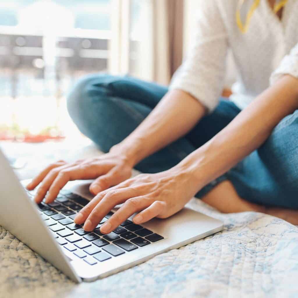 A freelance writer typing on a computer